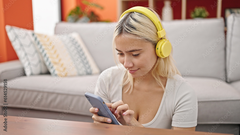 Young beautiful hispanic woman using smartphone and headphones sitting on floor at home Young beautiful hispanic woman using smartphone and headphones sitting on floor at home