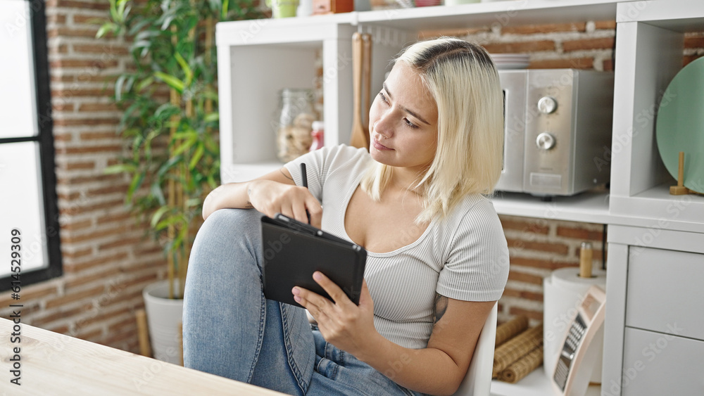 Young beautiful hispanic woman writing on touchpad sitting on table at dinning room Young beautiful hispanic woman writing on touchpad sitting on table at dinning room