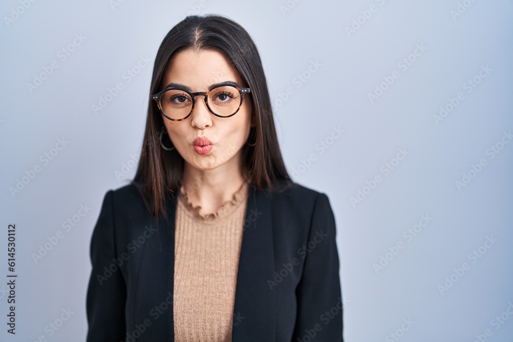 Young brunette woman standing over blue background making fish face with lips, crazy and comical gesture. funny expression. Young brunette woman standing over blue background making fish face with lips, crazy and comical gesture. funny expression.