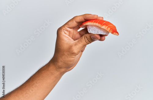  Hand of man holding prawn nigiri over isolated white background