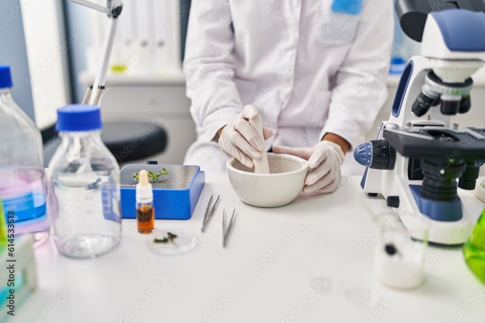 Fototapeta premium Young beautiful hispanic woman scientist mixing sample at laboratory