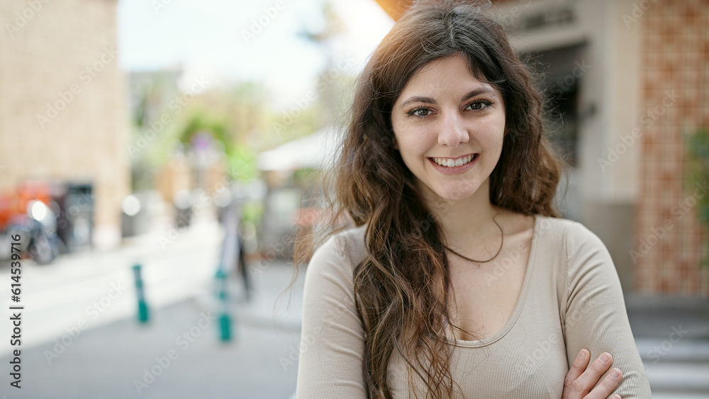 Young beautiful hispanic woman smiling confident standing with arms crossed gesture at street