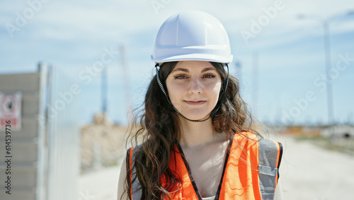 Young beautiful hispanic woman builder smiling confident standing at street