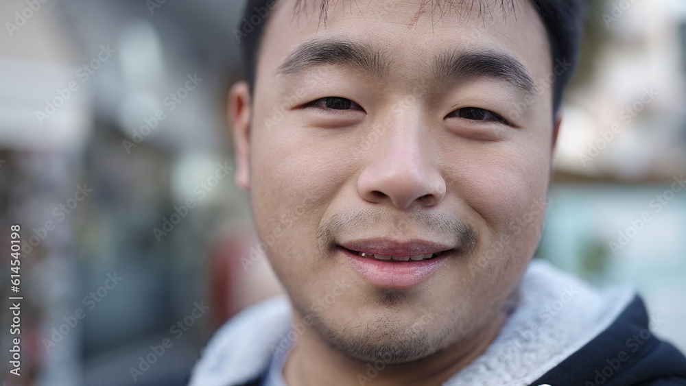 Young chinese man smiling confident standing at street Young chinese man smiling confident standing at street