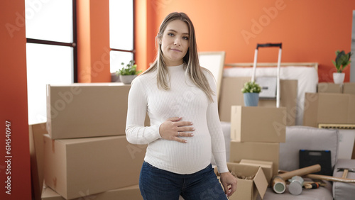 Young pregnant woman touching belly with relaxed expression at new home © Krakenimages.com