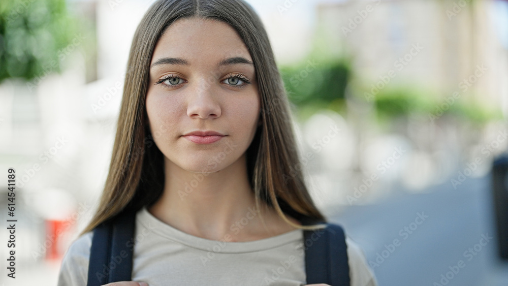 Young beautiful girl student wearing backpack with serious expression at street