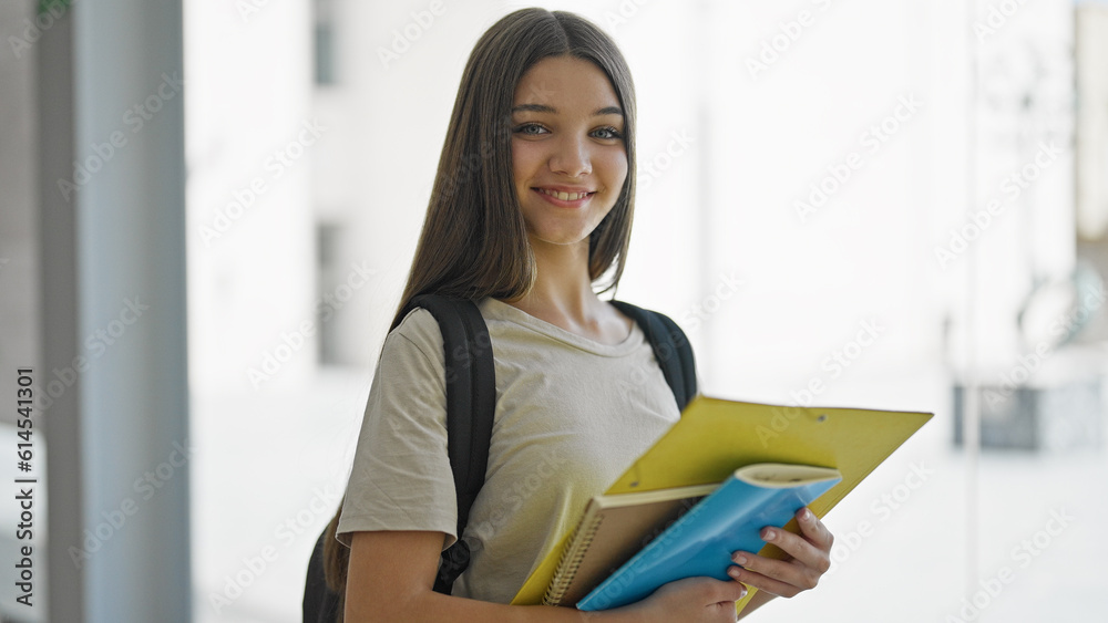 Young beautiful girl student wearing backpack holding books at library Young beautiful girl student wearing backpack holding books at library