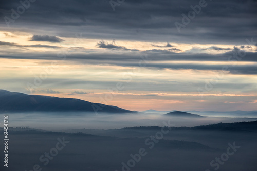 Mist and fog between valley and layers of mountains and hills at sunset, in Umbria Italy © Massimo