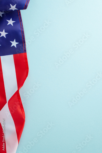 American federal holiday concept. High angle vertical view photo of the flag of United States of America on light blue isolated background with copy-space