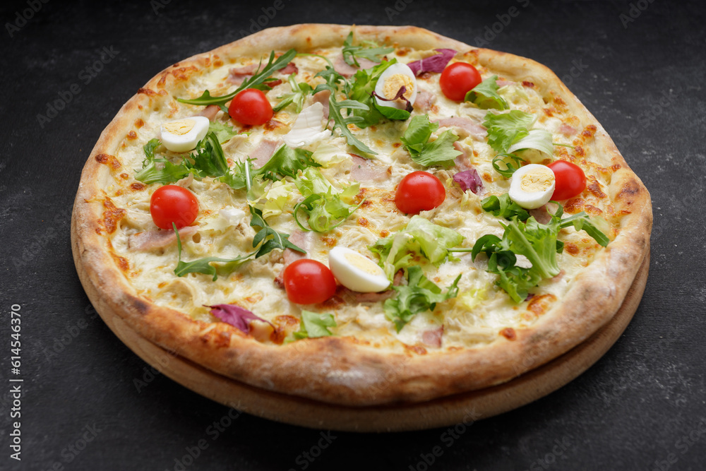 Appetizing Pizza Caesar, with meat, eggs, tomatoes and herbs