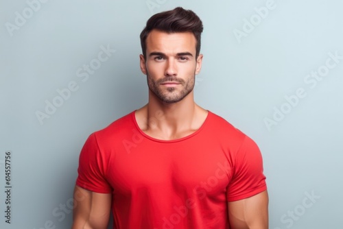 Portrait of a muscular handsome guy wearing a plain red t-shirt, isolated on a pastel background. Generative AI illustration.