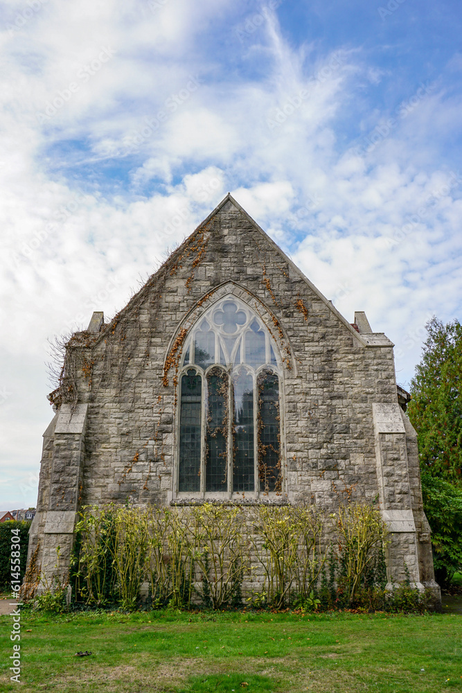 rear view of small chapel. Stone church exterior with large glass window. Religious building in the UK 