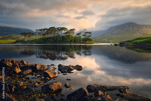 Beautiful sunrise landscape scenery of twelve pines island reflected in water surrounded by mountains at Derryclare lake, Connemara national Park in County Galway, Ireland 