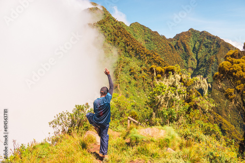 Rear view of a hiker on a wooden ladder at Mount Sabyinyo in the Virungas region at Mgahinga Gorilla National Park, Uganda photo