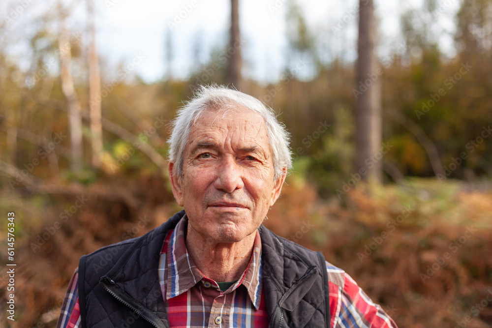 Portrait of an elderly man in the autumn forest. Selective focus.