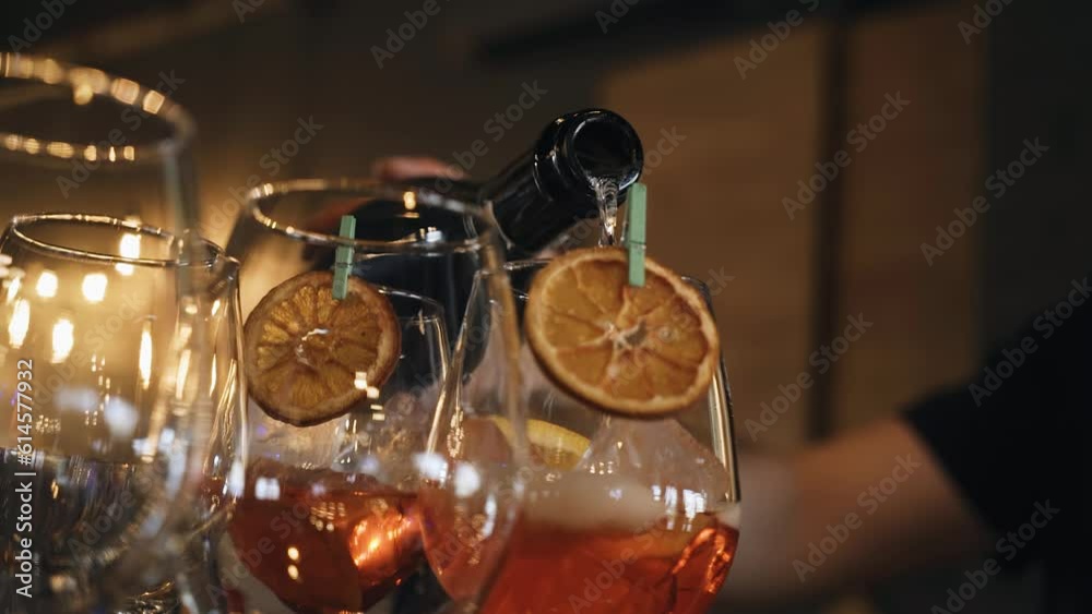 The bartender pours cocktail wine into glasses. Shooting close-up on the bar counter