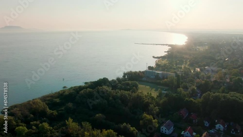 Panoramic drone view of Hungarian Lake Balaton and coast in Transdanubian region, Central Europe. Sunset presented above Waters of Port of Fonyod with shore and Green areas. 4k aerial shot photo