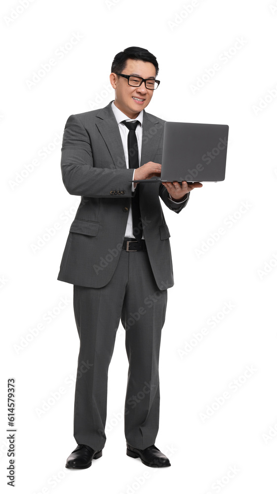 Businessman in suit working on laptop against white background