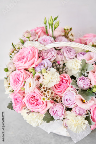 Flower arrangement in Wicker basket. Beautiful bouquet of mixed flowers on a marble table. Floral shop concept . Handsome fresh bouquet. Flowers delivery