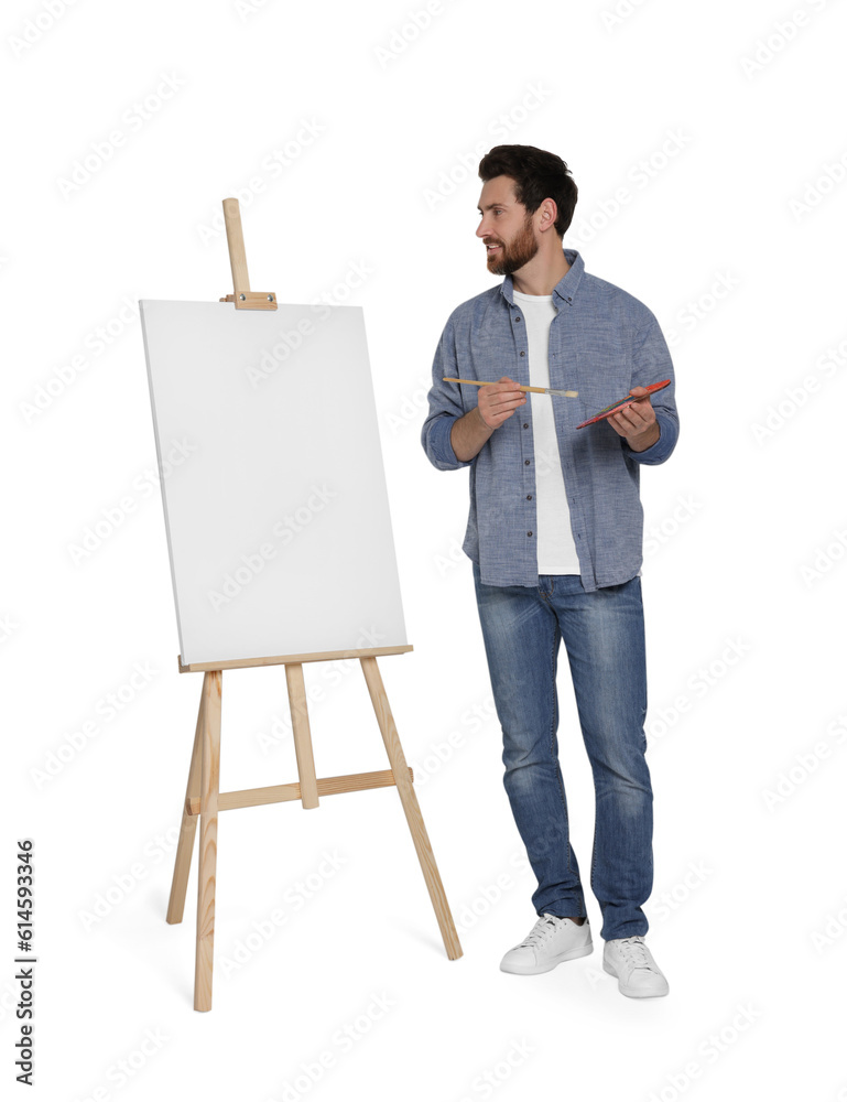 Happy man with brush and artist`s palette near easel with canvas against white background. Creative hobby Happy man with brush and artist`s palette near easel with canvas against white background. Creative hobby