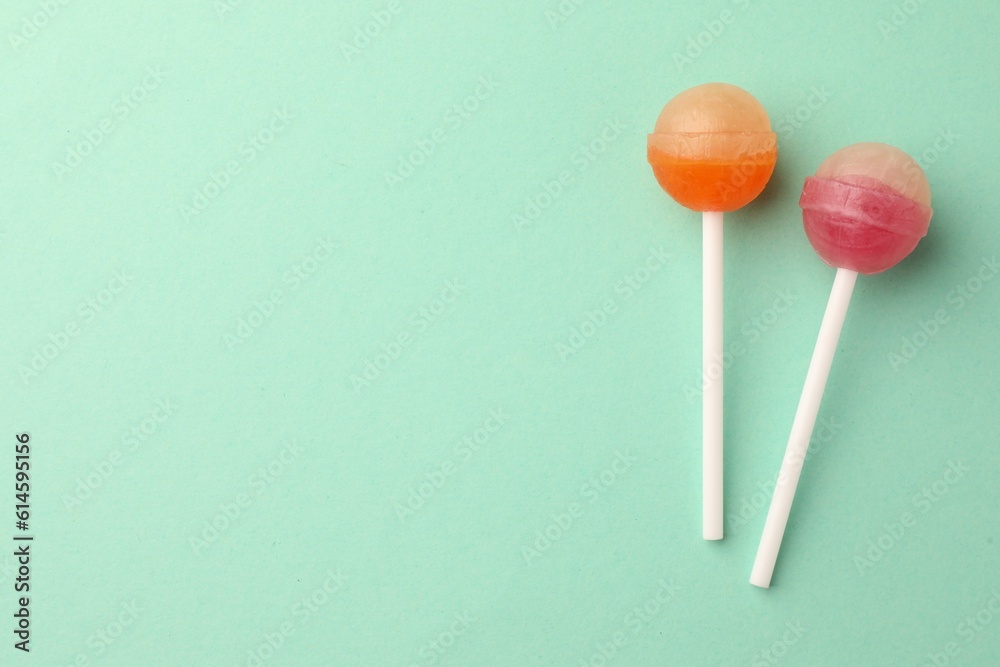 Tasty lollipops on turquoise background, flat lay. Space for text Tasty lollipops on turquoise background, flat lay. Space for text