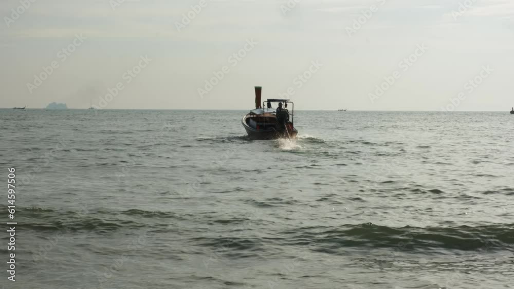 Longtail sea boat speeding off at Thailand beach seaside during a golden sunset Longtail sea boat speeding off at Thailand beach seaside during a golden sunset