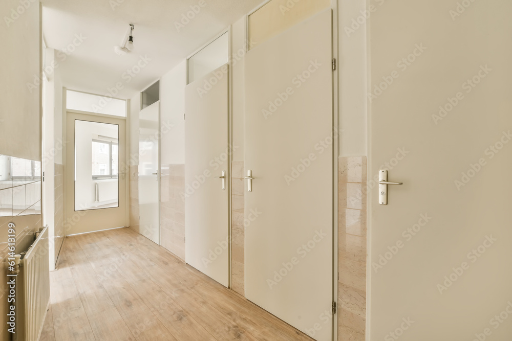 an empty room with wooden floors and white doors on either side, there is no one person in the photo an empty room with wooden floors and white doors on either side, there is no one person in the photo