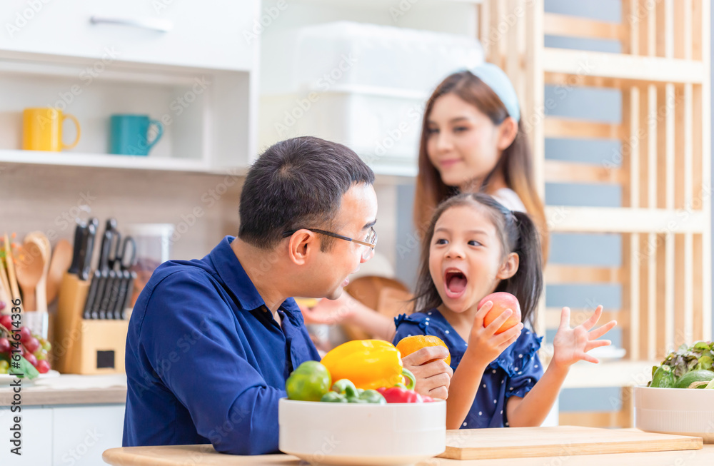 Father mother and daughter cooking together in the kitchen, Happy Asian family concepts Father mother and daughter cooking together in the kitchen, Happy Asian family concepts
