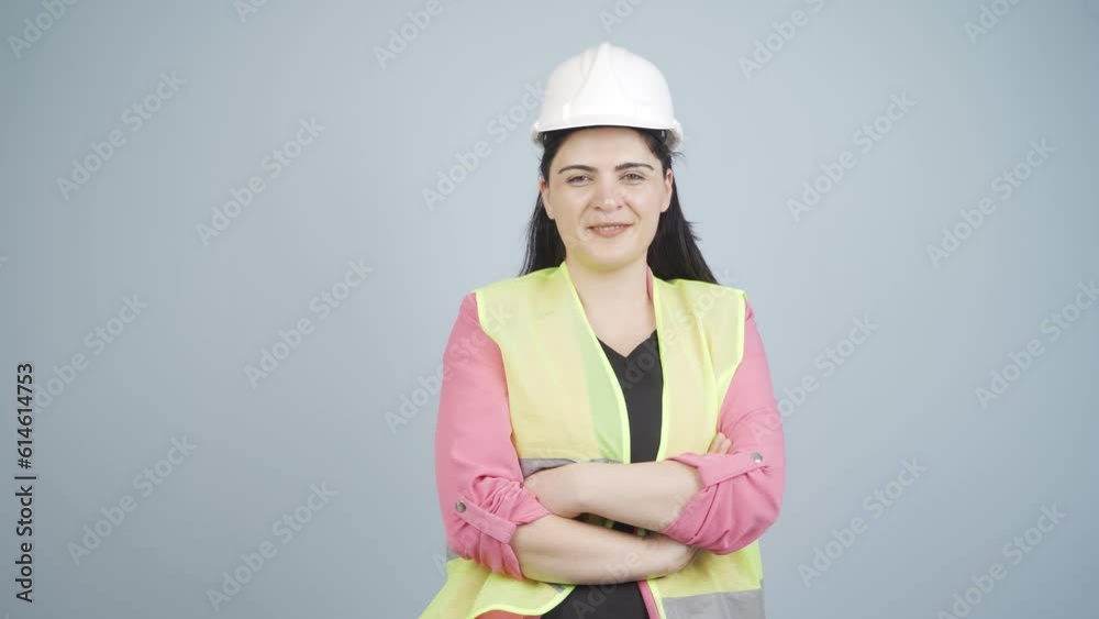 The engineer folds her arms and laughs at the camera. The engineer folds her arms and laughs at the camera.