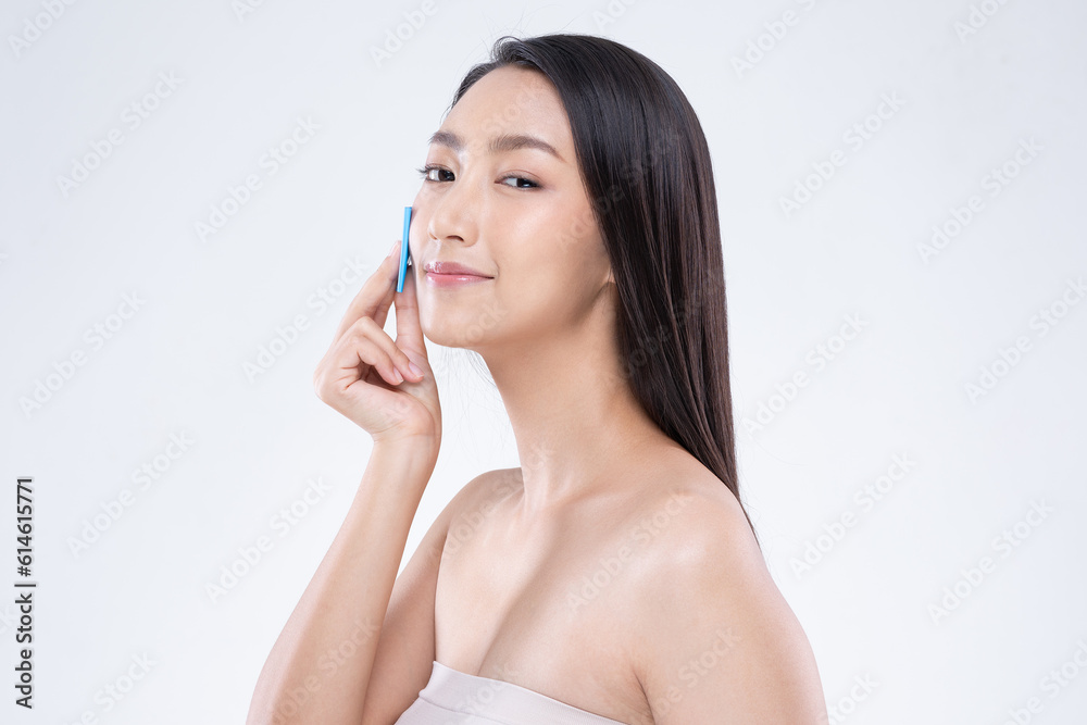 Beautiful Attractive Asian woman using Facial oil clean film to removal oily on face for face fresh skin feeling so fresh and clean,Beauty Self Care Concept,Isolated on grey background Beautiful Attractive Asian woman using Facial oil clean film to removal oily on face for face fresh skin feeling so fresh and clean,Beauty Self Care Concept,Isolated on grey background