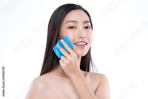 Beautiful Attractive Asian woman using Facial oil clean film to removal oily on face for face fresh skin feeling so fresh and clean,Beauty Self Care Concept,Isolated on grey background
