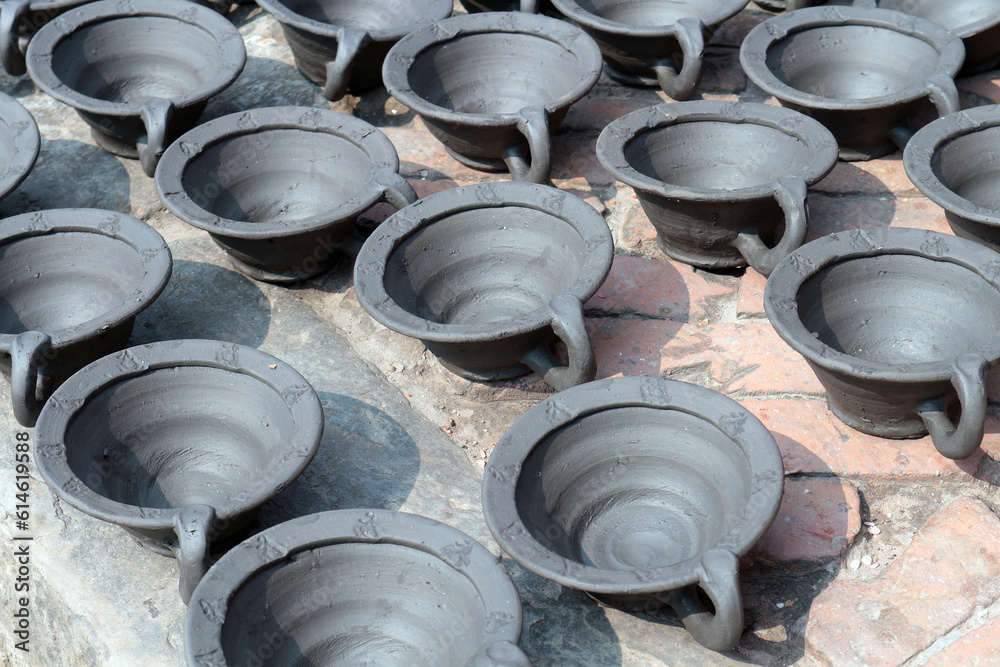 Many bowls of black clay are arranged in rows and dry in the sun. Handmade souvenirs in Bhaktapur, Nepal. Many bowls of black clay are arranged in rows and dry in the sun. Handmade souvenirs in Bhaktapur, Nepal.