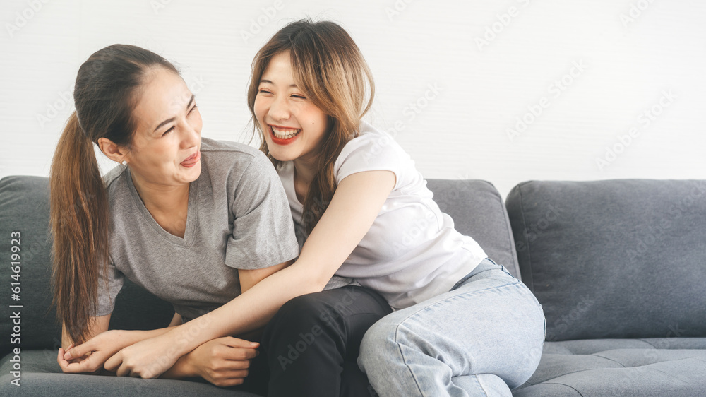 Two young woman couple funny embracing happy romantic moment on sofa at home