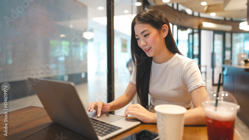 Business freelance asian woman using laptop computer at cafe urban lifestyle © dodotone