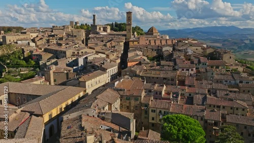 Aerial over town of Volterra and the Palace of the Priors, Palazzo dei Priori, Volterra, Province of Siena, Italy. Drone fast dolly forward photo
