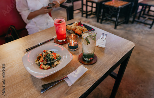 Dish of capcay and cheese fried banana dinner with fresh drink of apple breeze and strawberry breeze by candlelight on wooden table. photo