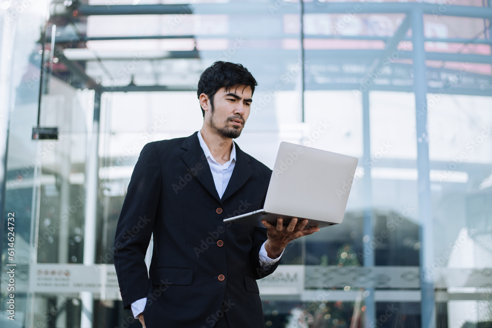 Asian businessman holding laptop.Office worker at business center Asian businessman holding laptop.Office worker at business center