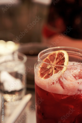 Cropped photo of a glass Raspberry ice tea top with a dehydrated lemon slice                                                             photo