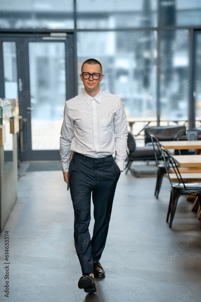 Man in formal wear carrying laptop walking to cafe for remote work. Man in formal wear carrying laptop walking to cafe for remote work.