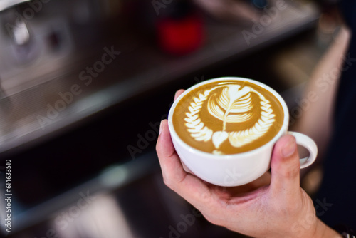 close up of a hand holding a cup of coffee
