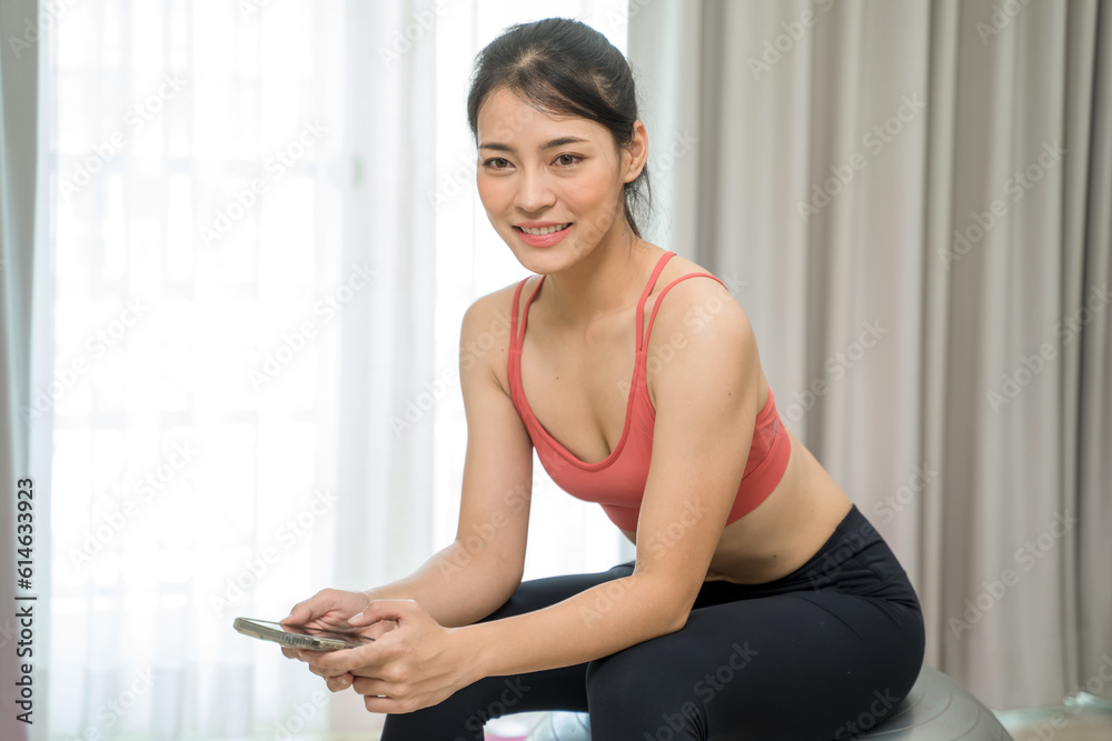 Beautiful woman exercising fitness at home and talking to mobile phone, Home interior, Fitness mat.