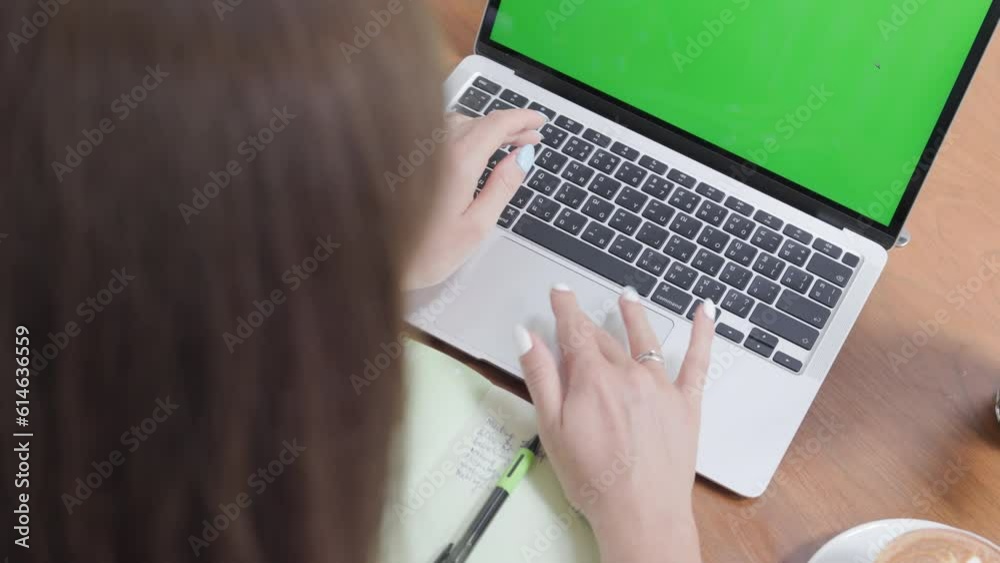 In a close-up side view, a professional businesswoman, online technology, types on a laptop keyboard at home office desk while the device displays a green screen for chroma key . In a close-up side view, a professional businesswoman, online technology, types on a laptop keyboard at home office desk while the device displays a green screen for chroma key .