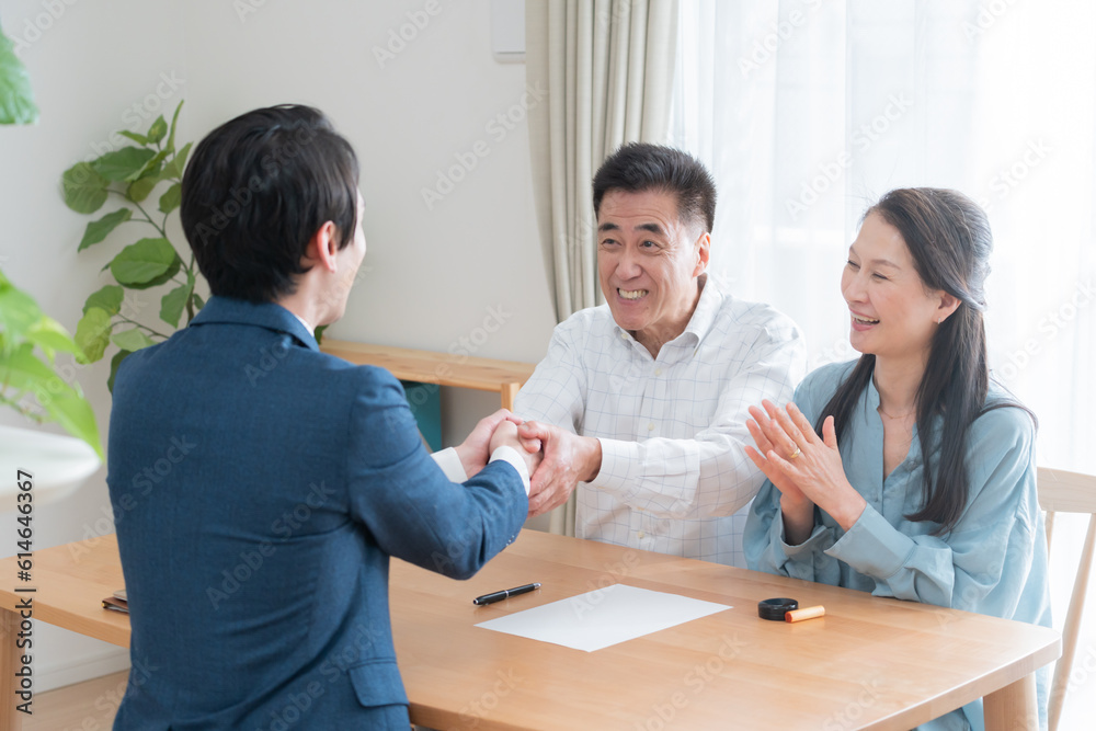営業マンと握手する高齢者夫婦 営業マンと握手する高齢者夫婦