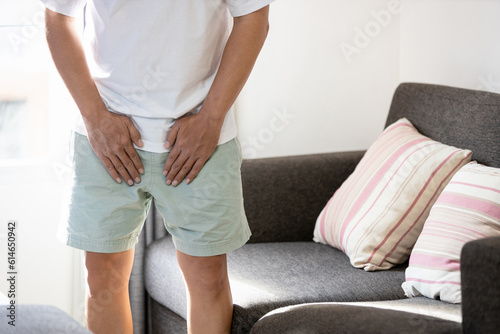 .Asian middle aged man suffering from inguinal hernia,groin lymph node swollen,hernia pain,male patient holding crotch,groin strain,painful in testicle,illness problems,health care and medical concept photo