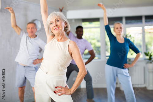 Group of multinational sports aged people rehearsing modern dance in dance hall