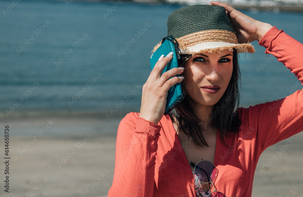 young woman with mobile phone on the beach
