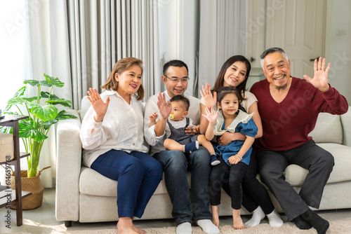 Portrait of happy love asian grandfather with grandmother playing with asian baby and little cute girl say bye, hallo.Big family love with father and mother smiling together.Family and togetherness.