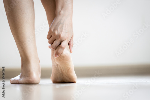 Tela Asian woman holding heel with her hand,symptom of Plantar Fasciitis,problem of a