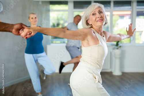 African American man is enjoying his hobby of dancing salsa with his elderly partner at fitness class, relishing in movement and activity. It great way for them to stay active and have fun together. photo