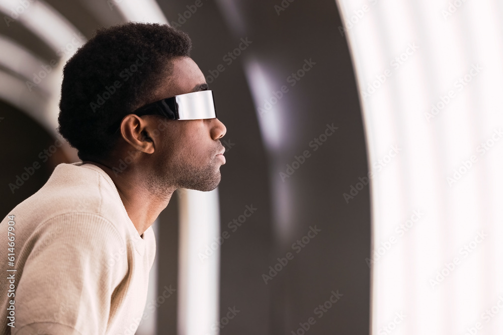 Futuristic man with cyber glasses looking at light pane Futuristic man with cyber glasses looking at light pane